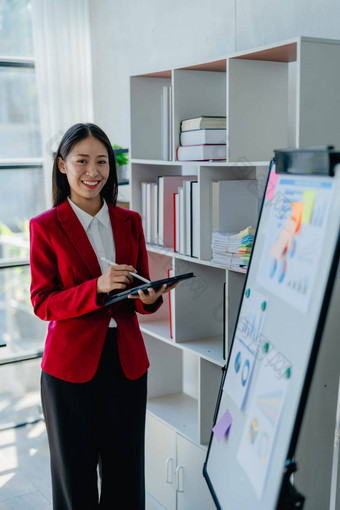 肖像美丽的年轻的亚洲女商人礼物业务利润的同事们会议解释业务转<strong>白板</strong>纸上的内容同事办公室平<strong>板</strong>电脑