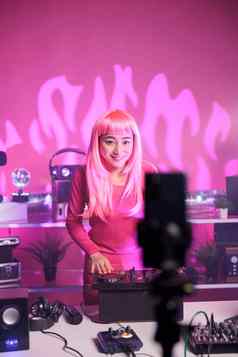 女人粉红色的头发玩电子首歌专业混合机控制台记录过程移动电话