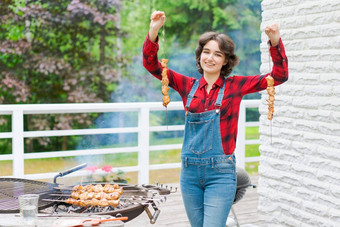 <strong>烧烤</strong>聚会，派对花园年轻的女人牛仔布工作服红色的格子衬衫