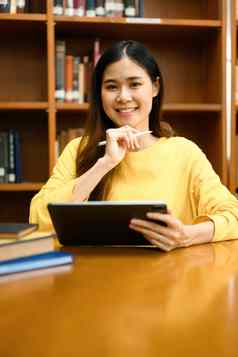 有吸引力的女学生数字平板电脑搜索在线信息图书馆教育技术概念