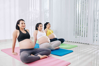 快乐漂亮的年轻的越南怀孕了女性坐着<strong>瑜伽垫培训</strong>类