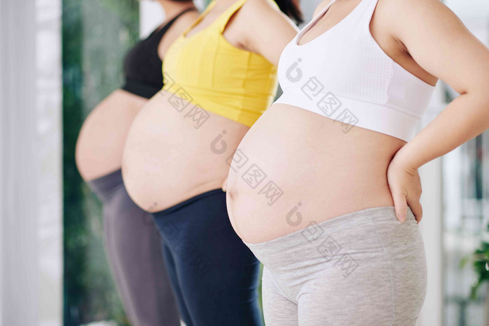 裁剪图像怀孕了女性站行参加瑜伽类健康俱乐部