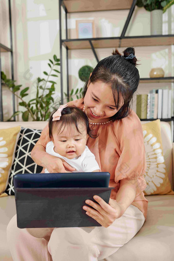快乐年轻的越南女人显示教育视频应用程序平板电脑电脑婴儿女孩