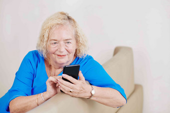 微笑上了年纪的女人检查文本<strong>消息通知</strong>智能手机