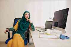 自信穆斯林女软件开发人员传统的衣服戴坐着办公室表格