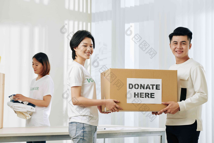 积极的越南志愿者携带盒子捐赠衣服