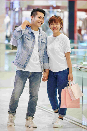 垂直完整的拍摄时尚的亚洲夫妇站现<strong>代购</strong>物购物中心持有袋
