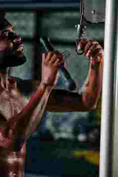 非洲美国男人。站袒胸改变健身机酒吧垂直拍摄