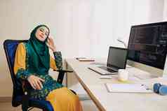 年轻的穆斯林女人短打破睡觉办公室椅子编程一天
