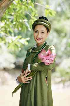 肖像快乐年轻的亚洲女人国家服装摆姿势莲花花