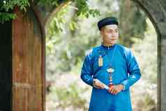 年轻的越南男人。蓝色的戴曼菊衣服走公园