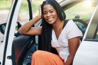 肖像快乐的年轻的黑色的女人长发绺坐着车打<strong>开通</strong>过
