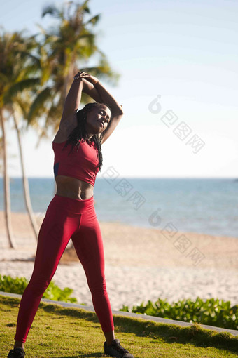 美丽的适合年轻的黑色的女人气候变暖慢跑海滩早....