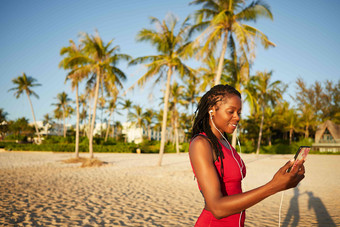 微笑适合女人看锻炼视频智能手机开始锻炼桑迪海滩