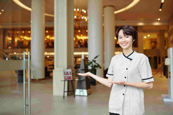 肖像快乐的越南酒店礼宾部使欢迎手势邀请客人酒店游说团体