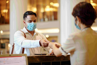 酒店接待员给数字房间关键客人医疗面具