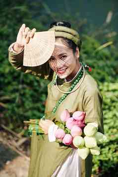 肖像微笑美丽的越南女人传统的衣服隐藏太阳雕刻风扇