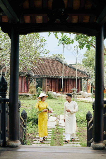 快乐年轻的亚洲夫妇戴曼菊礼服走寺庙