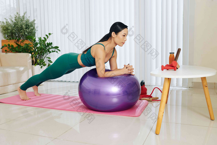 适合年轻的亚洲女人平衡健身球ABS锻炼平板电脑电脑