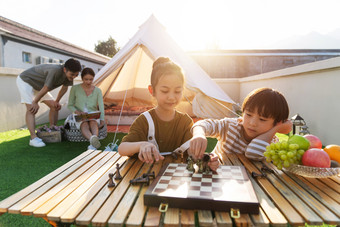 在户外露营的快乐儿童下国际象棋男人