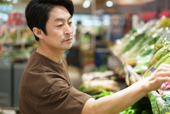 中年男性在超市挑选蔬菜顾客图片