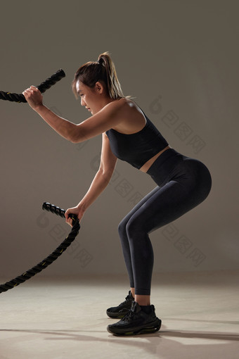 年轻女人健身绳子站着健身器械场景
