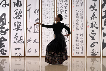 一位身穿民族服饰美女在书法前跳舞美女写实摄影