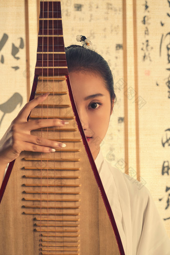 一位中国古装美女拿着琵琶站在书法作品前复古摄影