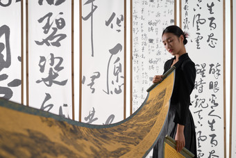 一位身穿民族服饰美女拿着古典式卷轴中国相片