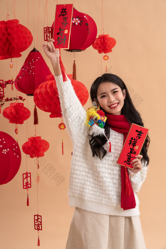 <strong>新年祝福</strong>，一位亚洲青年女性拿着春联龙年拍摄