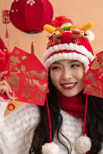 新年祝福，一位亚洲青年女性拿着红包灯笼写实摄影