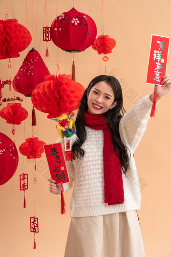 <strong>新年</strong>祝福，一位亚洲青年女性拿着<strong>春</strong>联高举手臂照片