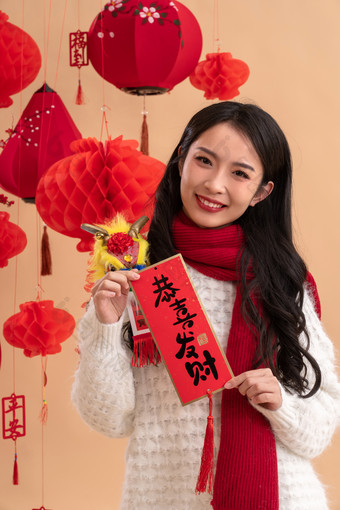 <strong>新年</strong>祝福，一位亚洲青年女性拿着春联灯笼图片