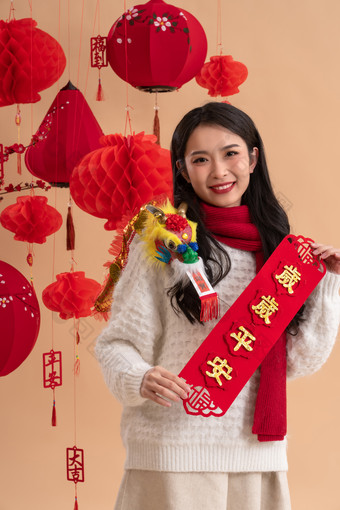 <strong>新年祝福</strong>，一位亚洲青年女性拿着春联庆祝