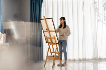 房间里一位亚洲华裔青年女人在绘画场景