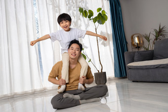 房间里一位亚洲男孩<strong>骑</strong>在父亲的<strong>肩膀</strong>上玩耍休闲摄影图
