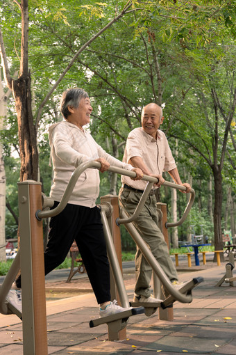 公园里使用锻炼器材锻炼的老年夫妇微笑素材