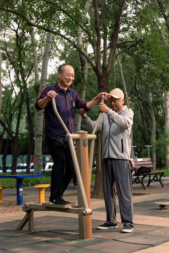 两位老年人在公园里使用锻炼器材