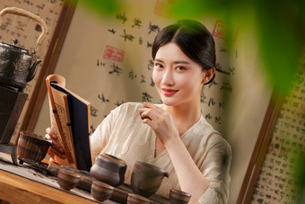 一位中国古典式女人看书喝茶陶瓦器镜头