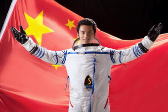 一个东方宇航员站在国旗下酷摄影图