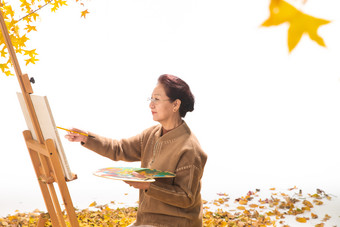 中老年女人在庭院里画画摄影图