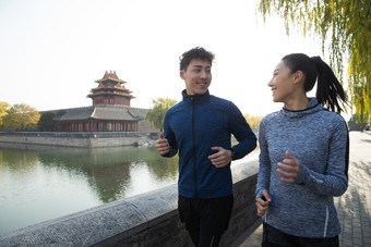 青年情侣慢跑护城河水平构图微笑的