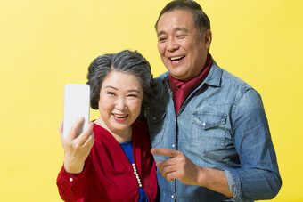 老年人看手机老年女人户内表情摄影图