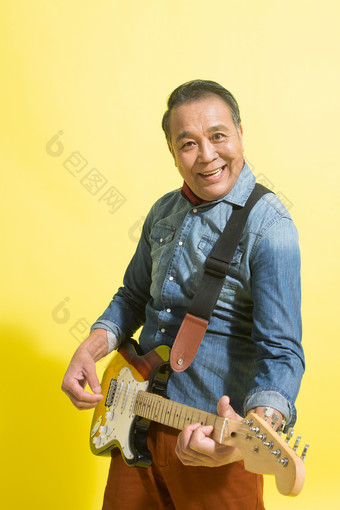 弹吉他老年男人快乐黄色背景相片