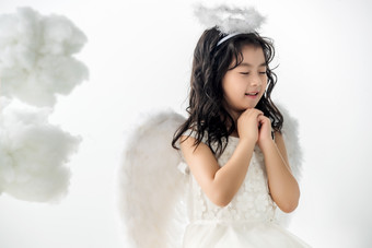 快乐的小天使做祈祷紧握双手影相