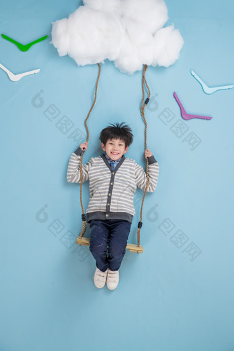 快乐男孩在云朵上荡秋千绳索相片