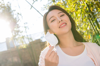 在户外拿着口罩的青年女人病毒素材