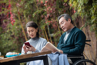 老年夫妇看书通讯户外影相