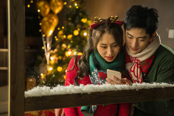 快乐的年轻伴侣在家使用<strong>手机</strong>圣诞节照片