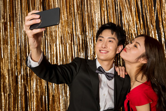 快乐的青年伴侣拿着手机自拍拿着摄影图